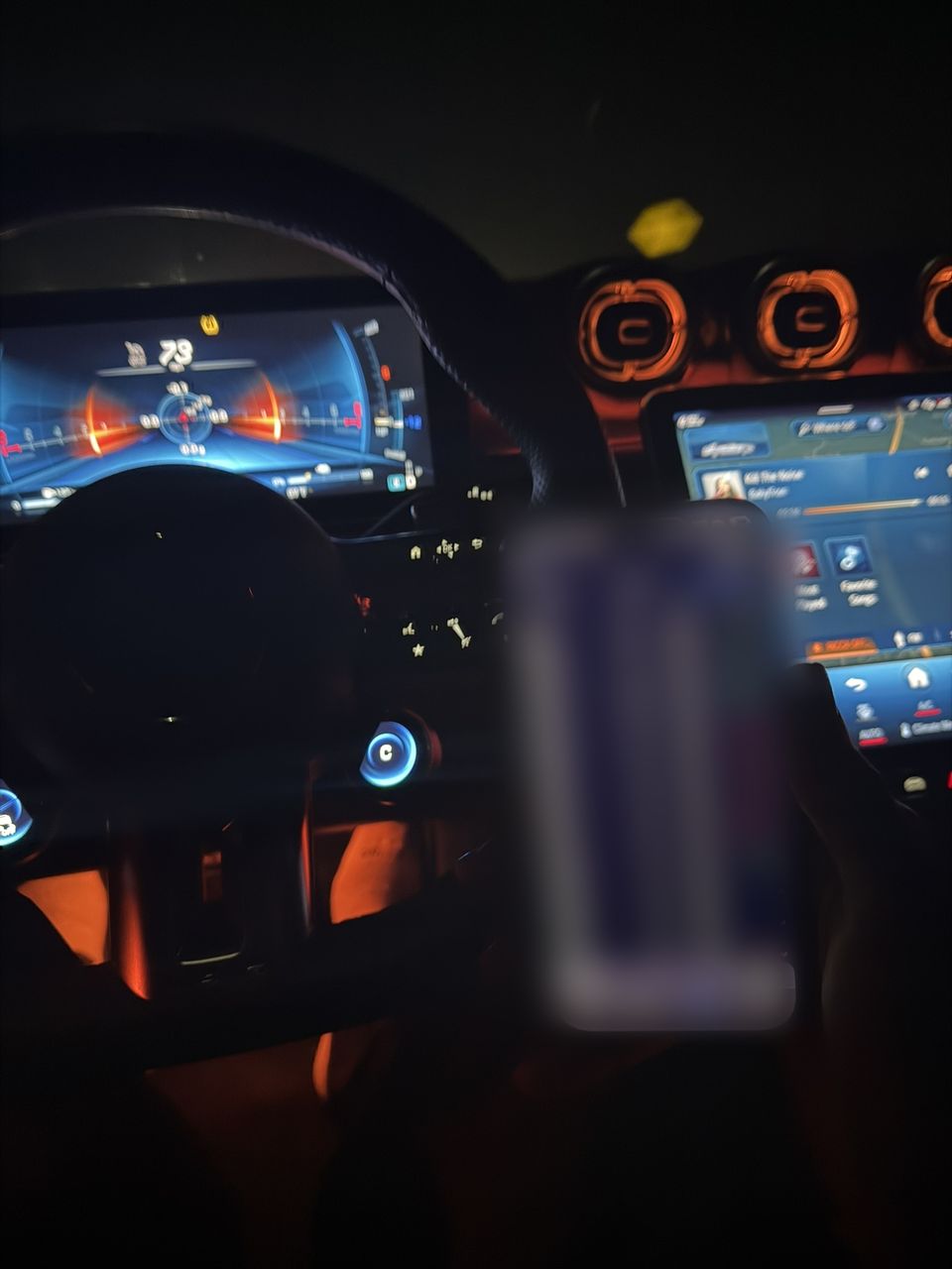 Melo at the wheel with the trading app open on his phone